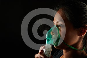 Close up view of woman using inhalation mask