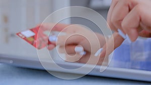 Close up view - woman using tablet device and credit card for online shopping