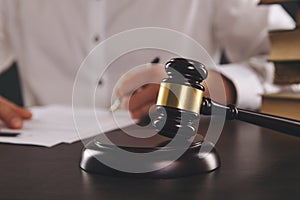 Close up view of wooden gavel. Male attorney working with paper documents.