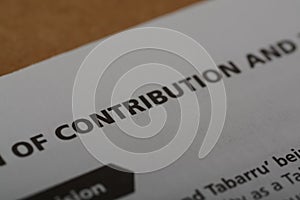 Close up view of the word CONTRIBUTION. contribution typically refers to the financial support or investment that an individual,