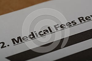 Close up view of the word MEDICAL FEES. Medical fees refer to the charges or fees that healthcare providers for their services,