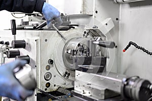 Close up view of worker operating a high precision turning operation on a multi axis lathe, CNC machine tool.