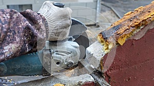 Close-up view of a worker working with angle grinder. Electric wheel grinding on steel structure. Sparks.