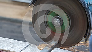 Close-up view of a worker working with angle grinder. Electric wheel grinding on steel structure. Sparks.