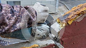 Close-up view of a worker working with angle grinder. Electric wheel grinding on steel structure. Sparks.