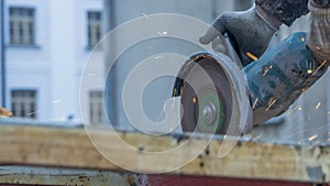 Close-up view of a worker working with angle grinder. Electric wheel grinding on steel structure. Sparks.