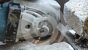 Close-up view of a worker working with angle grinder. Electric wheel grinding on steel structure. Sparks.