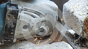 Close-up view of a worker working with angle grinder. Electric wheel grinding on steel structure. Sparks.