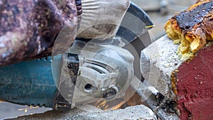 Close-up view of a worker working with angle grinder. Electric wheel grinding on steel structure. Sparks.