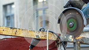 Close-up view of a worker working with angle grinder. Electric wheel grinding on steel structure. Sparks.