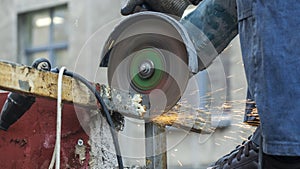 Close-up view of a worker working with angle grinder. Electric wheel grinding on steel structure. Sparks