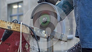 Close-up view of a worker working with angle grinder. Electric wheel grinding on steel structure. Sparks