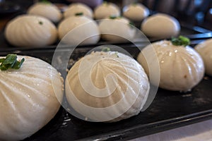 Close up view of xiao long bao in a steamer basket inside a restaurant