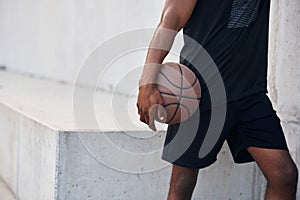 Close up view. Young black man is with basketball ball outdoors