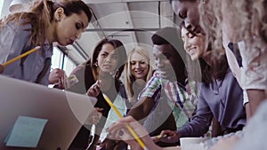 Close-up view of young business team with female team leader working together near the table, actively brainstorming.