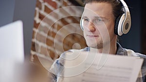 Close up view of a young pianist or guitarist trying to compose his new song in a deserted cafe duting coffee break