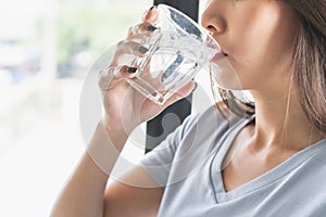 Close up view of woman drinking pure mineral water in a glass