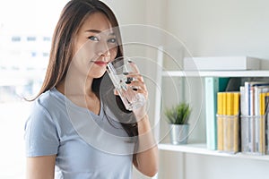 Close up view of young woman drinking pure mineral water in a glass