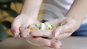 Close up view of young woman holding ginseng vitamins and minerals pills