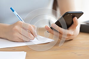 Close up view young woman holding smartphone in hands.