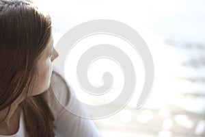 Close up view of a young woman looking out at the water