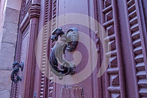 Close up of vintage aged door handle on a red wooden door