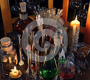 Close up of vintage bottles, flask and candles in alchemy laboratory