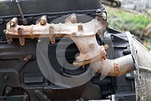 Close-up of the vintage engine of an old boat with a much rusty exhaust pipe engine