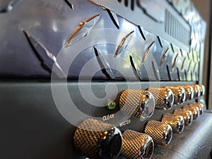 Close-up vintage head power amplifier with silver knob and black control panel. clean and hi-gain distortion.