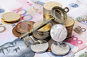 Close up of Vintage key with coins stack and china banknote
