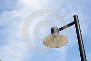 Close up vintage lamp and pole in the garden park and blie sky background. Electrical light in the night. photo