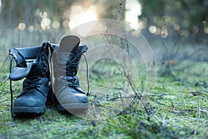 Close up of vintage pair of walking boots on boulder grassland background.