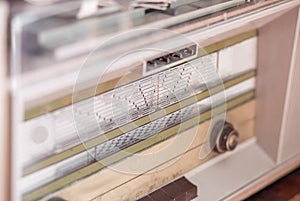 Close-up of a vintage radio with a horizontal tuning scale displaying various frequency numbers . photo