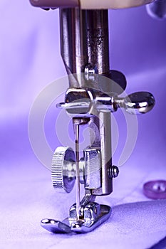 Close up of a vintage sewing machine and lilac cotton