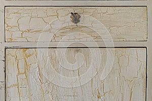 Close-up of vintage style cracked chest of drawers and white color