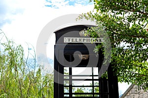 Close up of vintage telephone booth in a garden with copy space