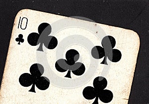 Close up of a vintage ten of clubs playing card on a black background.