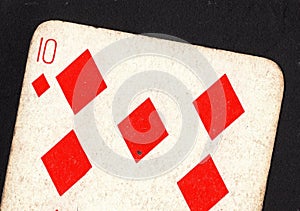 Close up of a vintage ten of diamonds playing card on a black background.