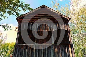 Close-up of vintage wooden windmill. Arched balcony with carved wooden platbands.