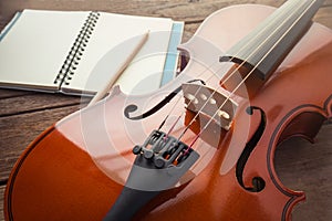 Close up of violin and book on wooden table