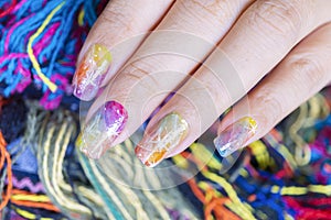 Close up vivid Colorful gel polish painting cute galaxy nail art on beautiful woman fingernail