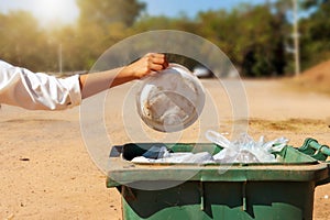 Close-up of a volunteer happily collecting plastic trash in a park