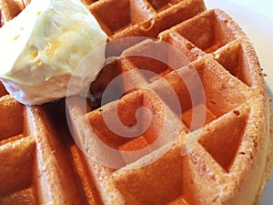 A Close Up Of A Waffle With Butter On Top