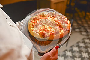 Close up of waiter serving a plate of Khachapuri - hachapuri in Adjarian. Waiter at work. Restaurant service.