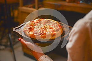 Close up of waiter serving a plate of Khachapuri - hachapuri in Adjarian. Waiter at work. Restaurant service.