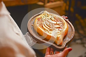 Close up of waiter serving a plate of Khachapuri - hachapuri in Adjarian. Waiter at work. Restaurant service