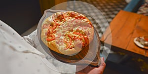 Close up of waiter serving a plate of Khachapuri - hachapuri in Adjarian. Waiter at work. Restaurant service