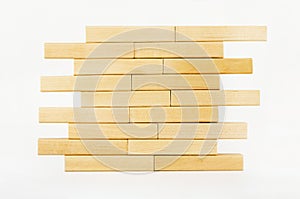 Close-up wall built with toy wooden blocks jenga. wooden brick tower on a white background