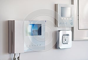 Close up wall with security alarm and video intercom photo
