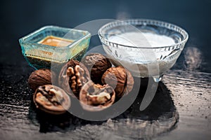 Close up of walnut face pack to prevent hair damage on wooden surface i.e. walnut powder well mixed with curd in a glass bowl with